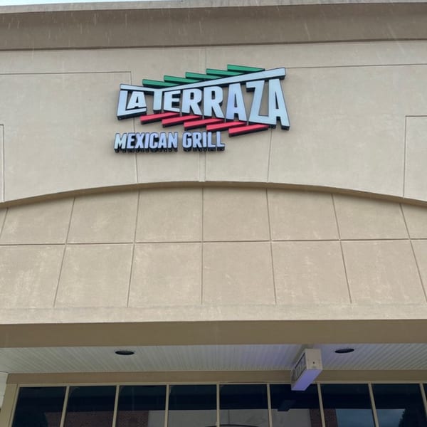 The exterior sign for La Terraza Mexican Grill, featuring green and red accents on a beige building.