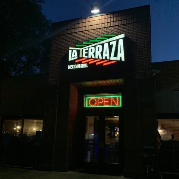 The exterior of La Terraza Mexican Grill at night, with its illuminated sign and an "OPEN" neon sign.