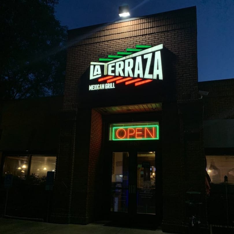 The exterior of La Terraza Mexican Grill at night, with its illuminated sign and an "OPEN" neon sign.